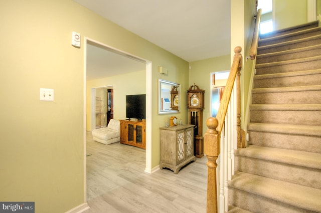 stairs with baseboards, a healthy amount of sunlight, and wood finished floors