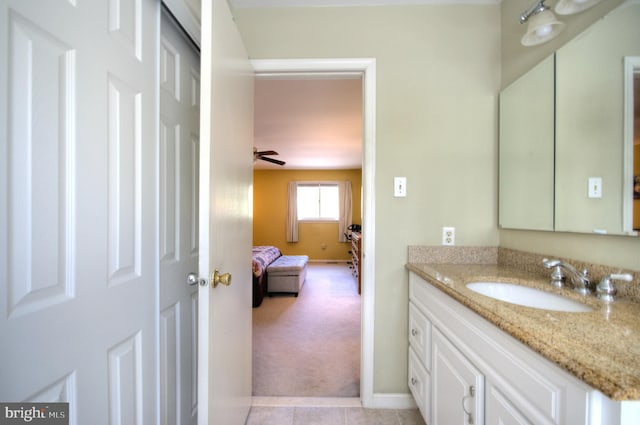 ensuite bathroom featuring connected bathroom, baseboards, tile patterned flooring, and vanity