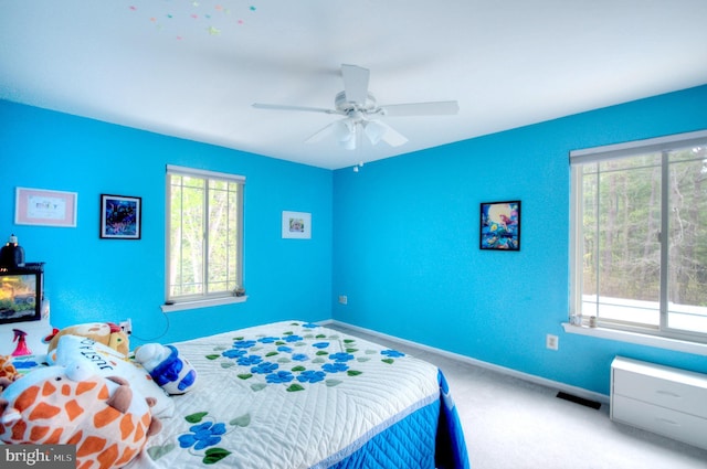 bedroom with carpet floors, baseboards, visible vents, and multiple windows