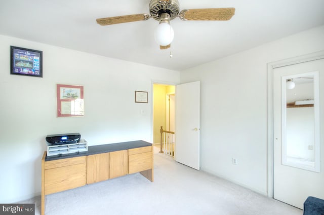 office space featuring a ceiling fan and light carpet