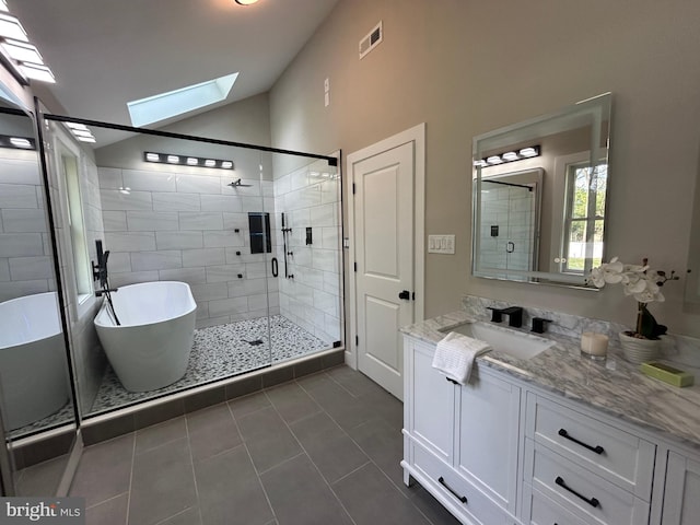 849 Glenn Cir, Wayne, PA 19087 - full bath featuring vaulted ceiling, a skylight, a shower stall, tile patterned flooring, and a freestanding bath
