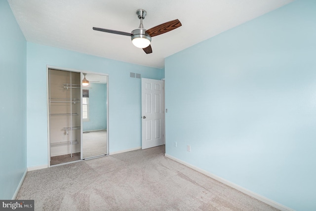 unfurnished bedroom featuring carpet flooring, a closet, baseboards, and a ceiling fan