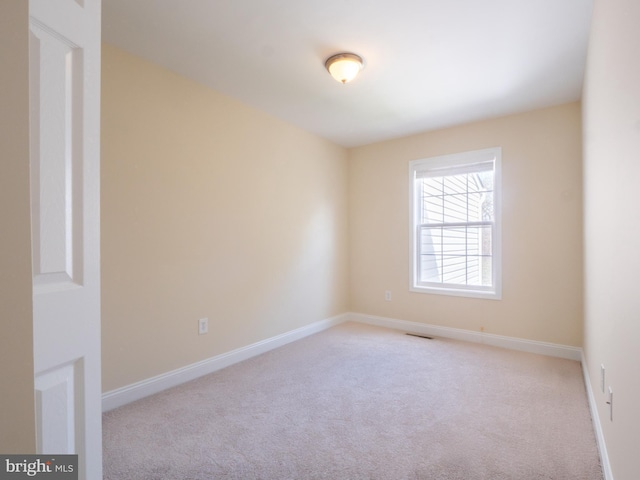 carpeted empty room with visible vents and baseboards