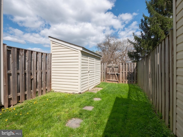 view of yard with a fenced backyard, an outdoor structure, and a storage unit