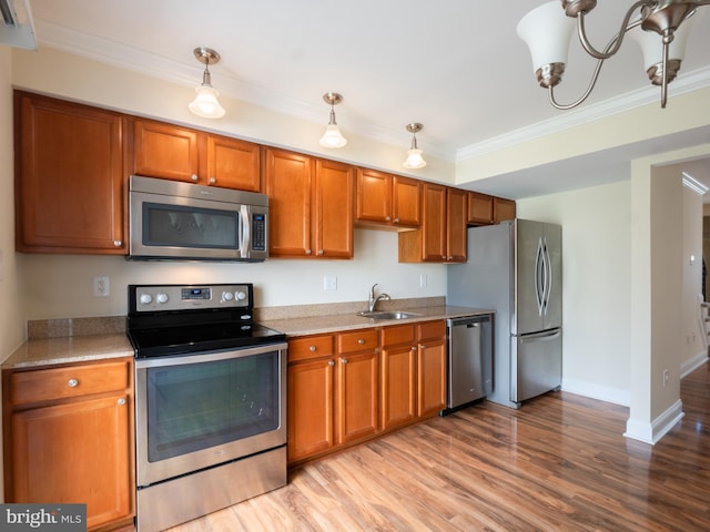 kitchen with brown cabinets, a sink, ornamental molding, and stainless steel appliances