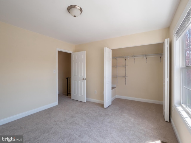 unfurnished bedroom featuring a closet, baseboards, and carpet flooring