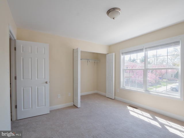 unfurnished bedroom featuring a closet, visible vents, baseboards, and carpet