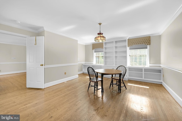 dining area featuring a wealth of natural light, crown molding, and wood finished floors