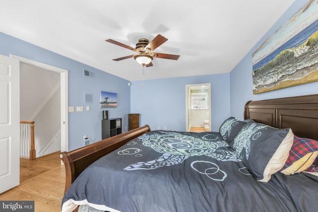 bedroom with wood finished floors, visible vents, ceiling fan, and connected bathroom