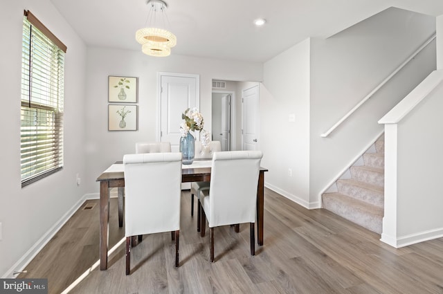 dining space with wood finished floors, baseboards, plenty of natural light, and stairway