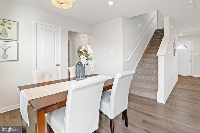 dining area with baseboards, recessed lighting, wood finished floors, and stairs