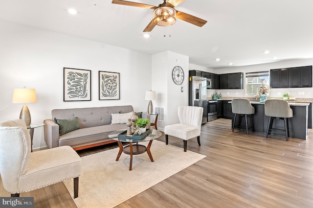 living room featuring visible vents, ceiling fan, light wood-type flooring, and recessed lighting