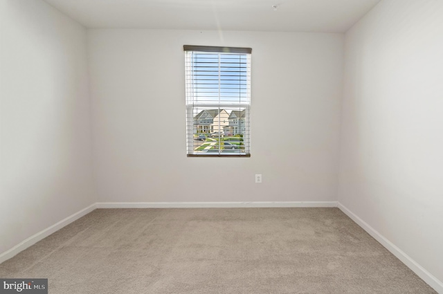 carpeted spare room with baseboards