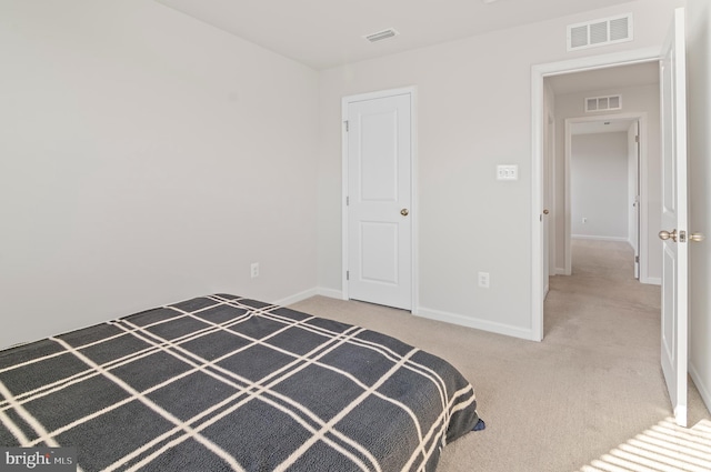 unfurnished bedroom featuring baseboards, carpet, and visible vents