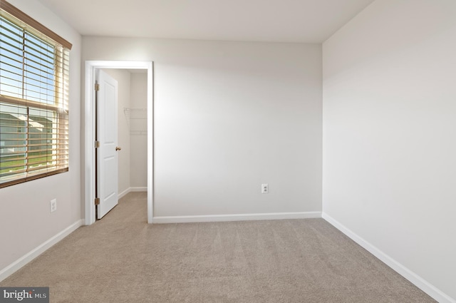 spare room with baseboards and carpet floors