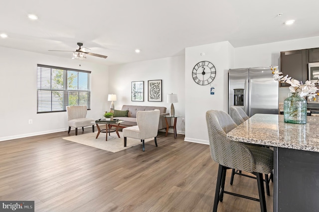 living area with baseboards, recessed lighting, ceiling fan, and wood finished floors