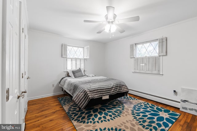 bedroom featuring multiple windows, hardwood / wood-style floors, and baseboard heating