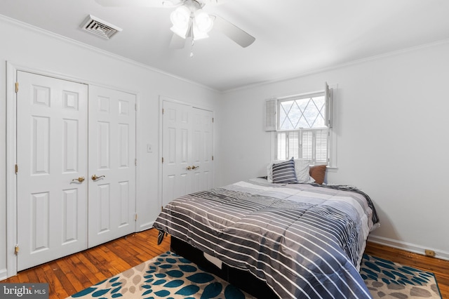 bedroom with visible vents, hardwood / wood-style flooring, and crown molding