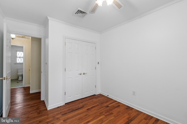 unfurnished bedroom featuring crown molding, wood finished floors, a closet, and visible vents