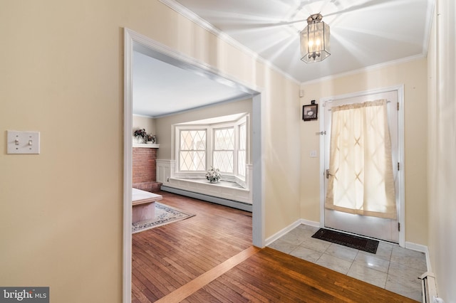 entryway with a notable chandelier, baseboards, a baseboard heating unit, crown molding, and hardwood / wood-style floors