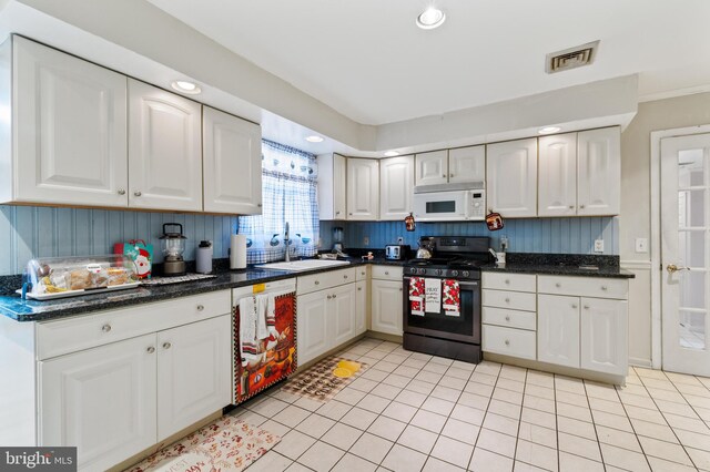 kitchen featuring visible vents, dishwasher, a sink, white microwave, and stainless steel gas stove