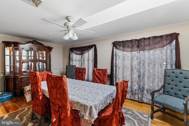 dining area featuring crown molding, wood finished floors, and ceiling fan