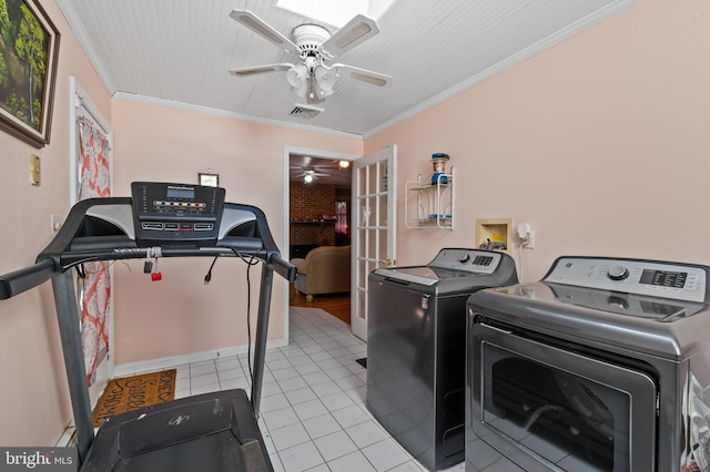 laundry area featuring laundry area, crown molding, ceiling fan, washing machine and clothes dryer, and tile patterned floors