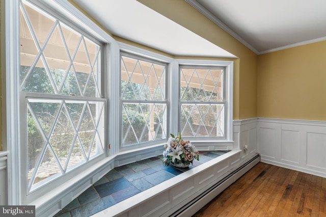 interior details featuring crown molding, wood finished floors, and a wainscoted wall
