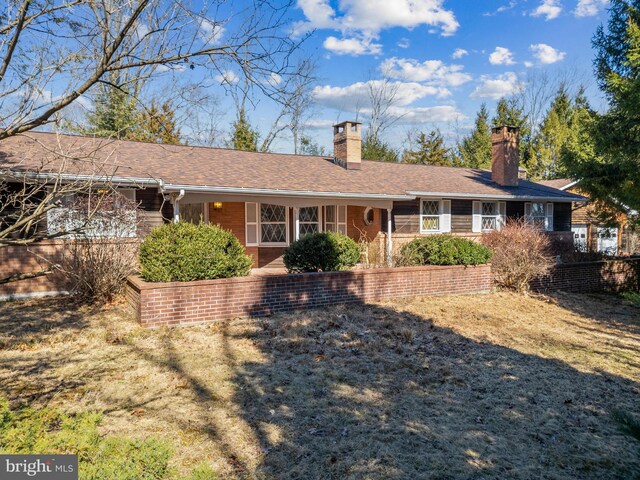 view of front of house featuring roof with shingles and a chimney