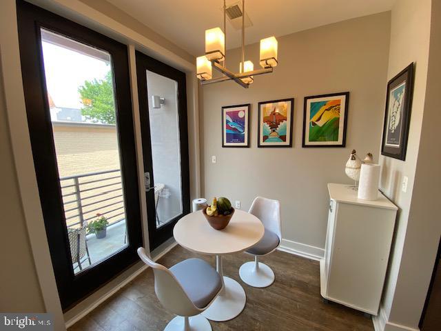 dining room featuring a chandelier, dark wood-style flooring, and baseboards