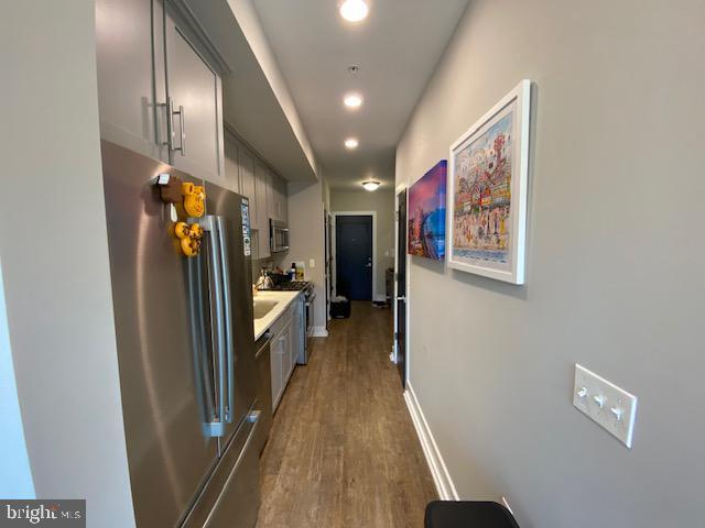 corridor featuring wood finished floors and baseboards