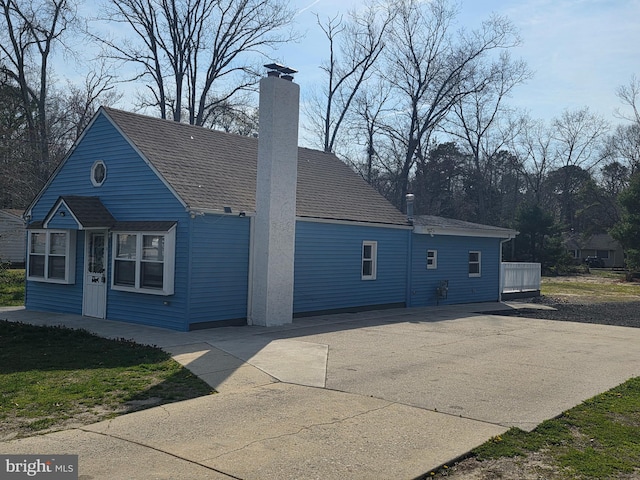 exterior space featuring driveway and a chimney