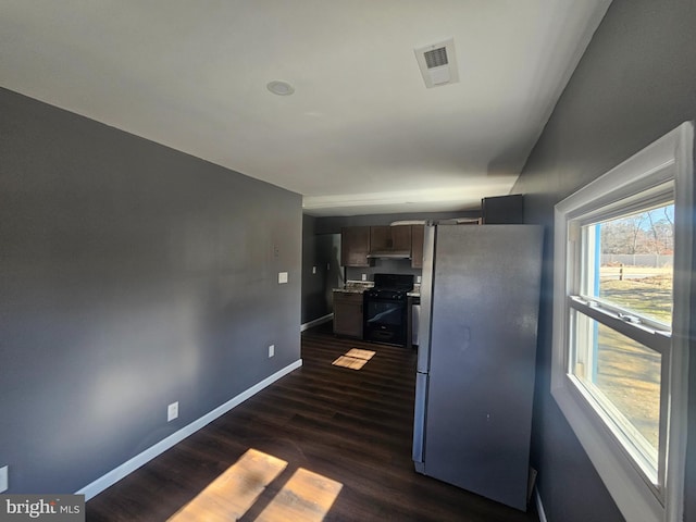 kitchen with baseboards, black range with gas cooktop, dark wood-style floors, freestanding refrigerator, and visible vents