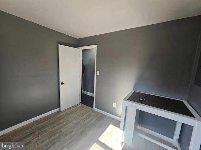 interior space with baseboards and wood finished floors