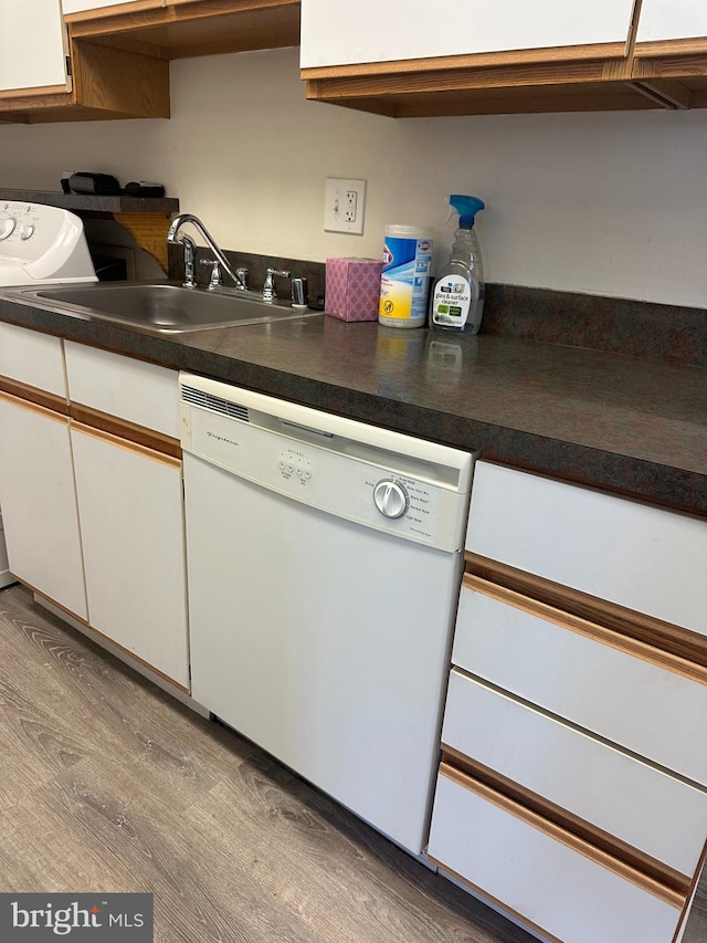 10206 Prince Pl Unit 4-204, Upper Marlboro, MD 20774 - kitchen with white cabinets, dishwasher, a sink, dark countertops, and wood finished floors