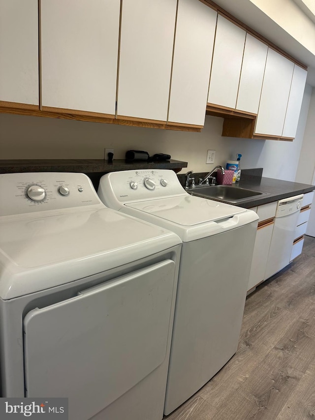 10206 Prince Pl Unit 4-204, Upper Marlboro, MD 20774 - laundry room with wood finished floors, washing machine and clothes dryer, a sink, and cabinet space