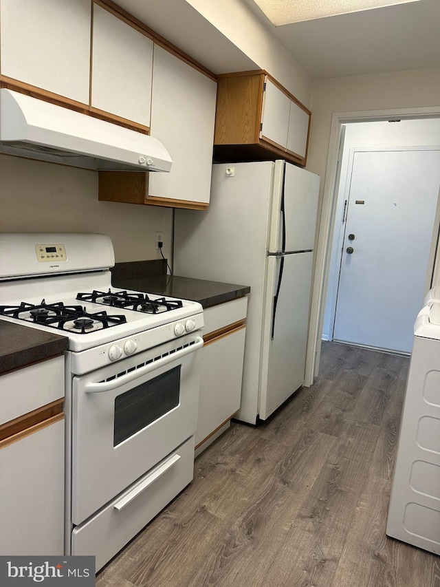 10206 Prince Pl Unit 4-204, Upper Marlboro, MD 20774 - kitchen featuring dark wood finished floors, dark countertops, white appliances, and under cabinet range hood