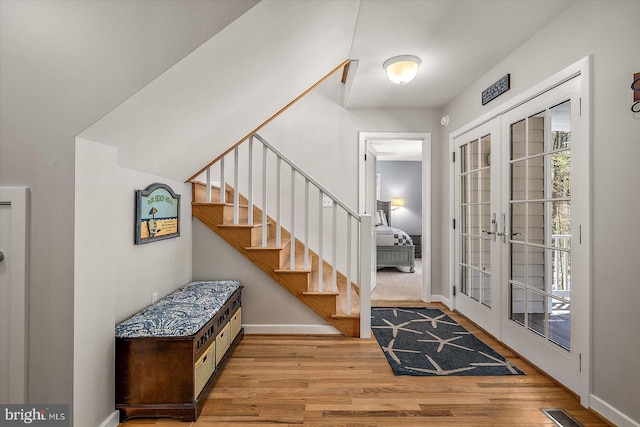 foyer entrance featuring stairway, wood finished floors, visible vents, french doors, and baseboards