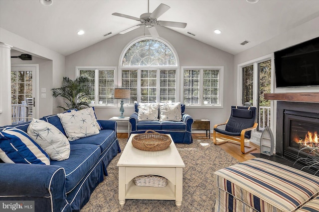 living area with wood finished floors, visible vents, lofted ceiling, and ceiling fan