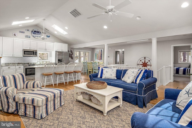 living area with a ceiling fan, a skylight, light wood-type flooring, visible vents, and recessed lighting