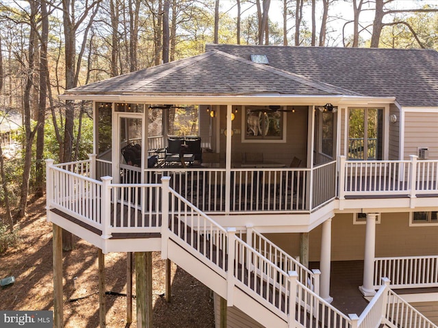 wooden deck featuring a sunroom and stairs