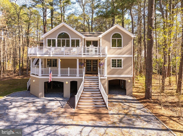 view of front facade featuring french doors, driveway, stairs, and a carport
