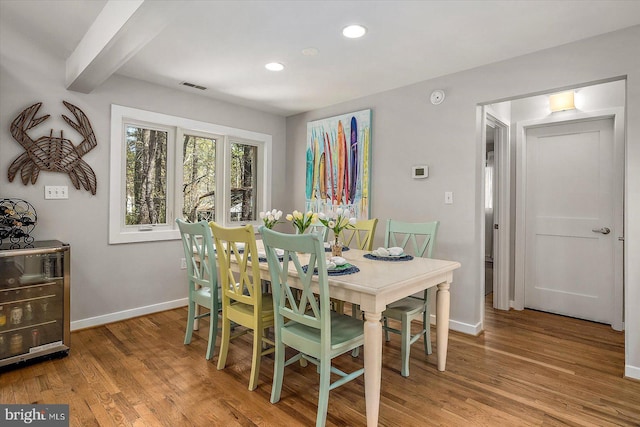 dining space with recessed lighting, visible vents, beamed ceiling, baseboards, and light wood-style flooring