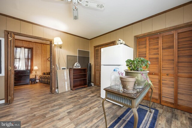 1036 S Schumaker Dr, Salisbury, MD 21804 - kitchen featuring a ceiling fan, wood finished floors, wooden walls, ornamental molding, and freestanding refrigerator