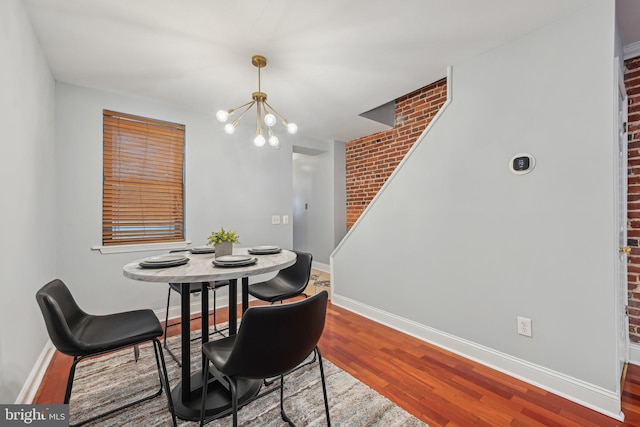 935 S Kenwood Ave, Baltimore, MD 21224 - dining area featuring brick wall, an inviting chandelier, baseboards, and wood finished floors
