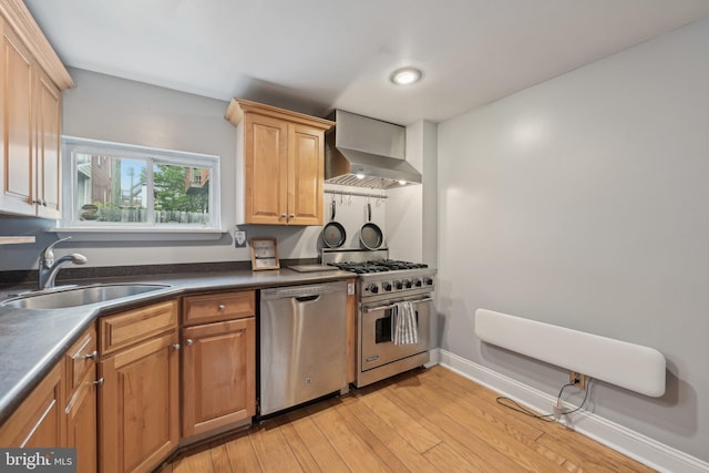 935 S Kenwood Ave, Baltimore, MD 21224 - kitchen featuring a sink, stainless steel appliances, wall chimney exhaust hood, dark countertops, and light wood-style floors