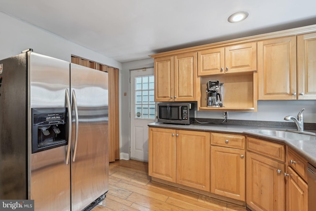 935 S Kenwood Ave, Baltimore, MD 21224 - kitchen with dark countertops, stainless steel appliances, light wood-style flooring, and a sink