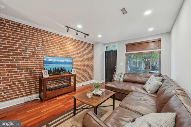 935 S Kenwood Ave, Baltimore, MD 21224 - living room featuring wood finished floors, visible vents, baseboards, and brick wall