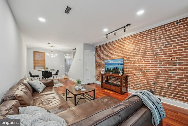 935 S Kenwood Ave, Baltimore, MD 21224 - living area featuring wood finished floors, brick wall, visible vents, baseboards, and a chandelier