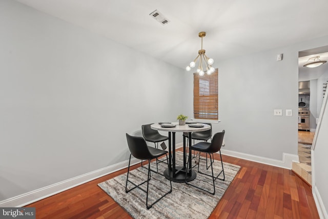 935 S Kenwood Ave, Baltimore, MD 21224 - dining area featuring an inviting chandelier, wood finished floors, visible vents, and baseboards